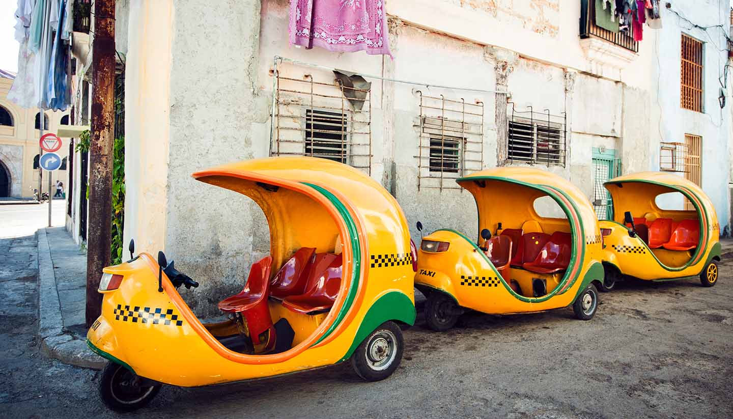 Coco-taxis parked at a street of Havana